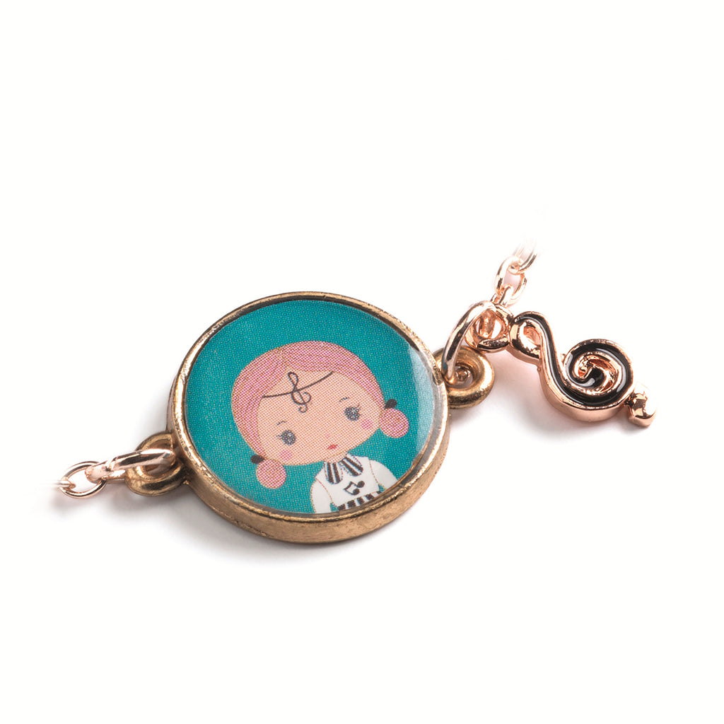 A children's bracelet from Djeco's Tinyly collection featuring a gold-colored chain and a charm of Sidonie, a character depicted with a musical note accessory.
