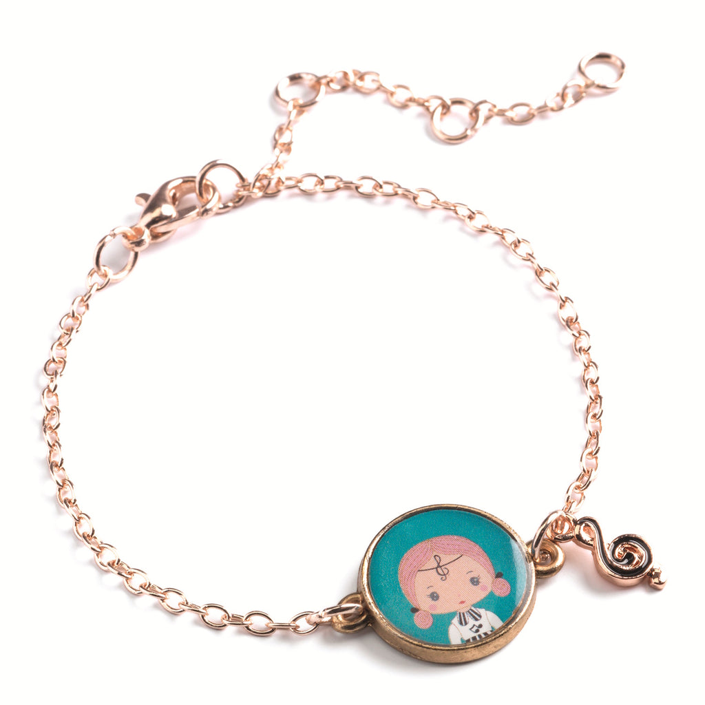 A children's bracelet from Djeco's Tinyly collection featuring a gold-colored chain and a charm of Sidonie, a character depicted with a musical note accessory.