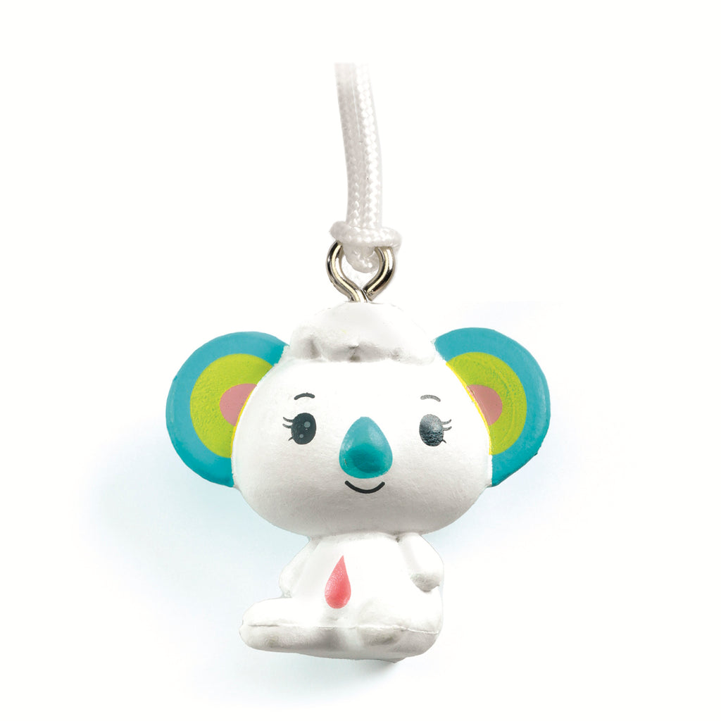A cute, stylized koala charm with colorful ears, a smiling face, and a small red drop on its chest, hanging from a white string.