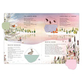Flat lay view of open paper 'Tis the Season Advent calendar book pages with open flaps revealing hidden illustrations.
