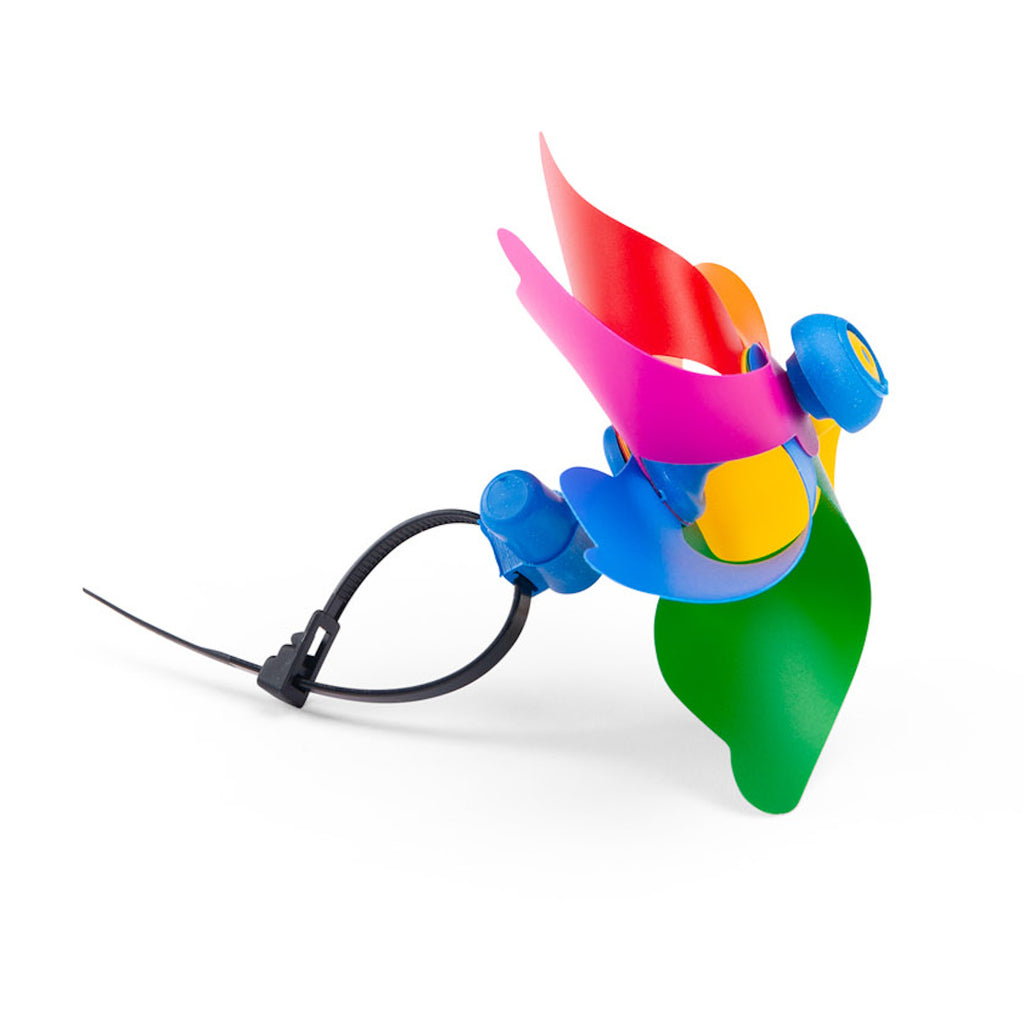 A colorful toy pinwheel with six vibrant blades in pink, red, orange, yellow, green, and blue against a white background, conveying a playful tone.