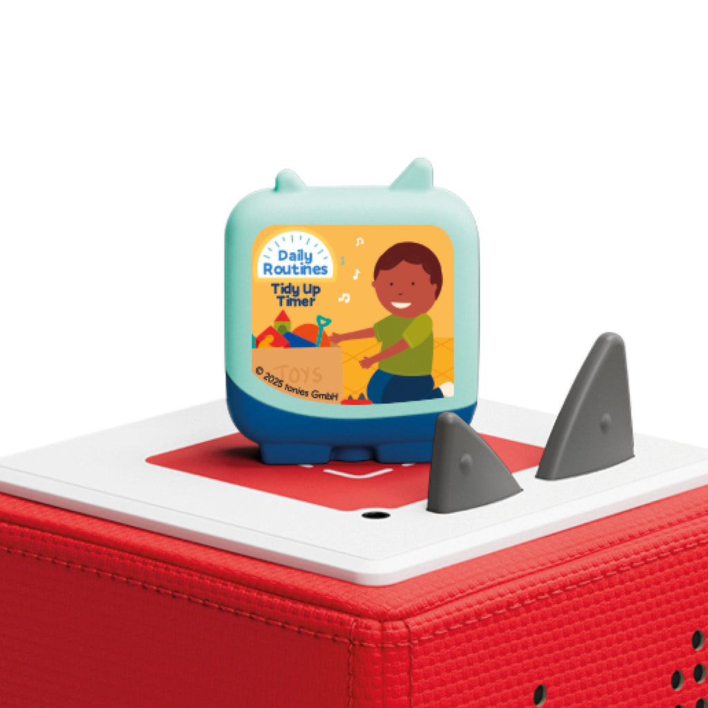 A Tidy Up Timer Tonie on a red Toniebox, featuring an illustration of a happy child cleaning up toys. The scene is cheerful, promoting daily routines.
