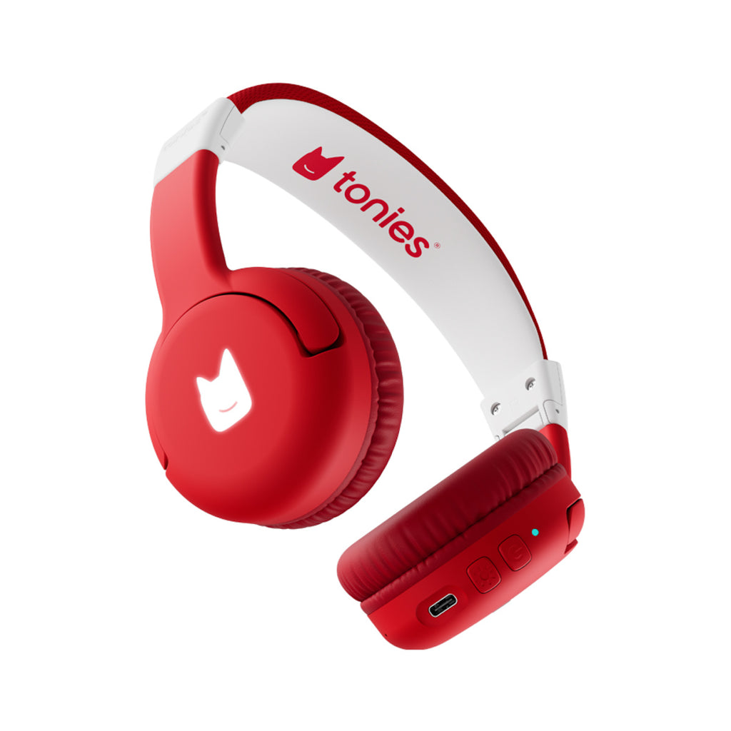 Red and white children’s headphones with a playful design. The red ear cups feature a light-up cat-like logo, USB port, and buttons below.