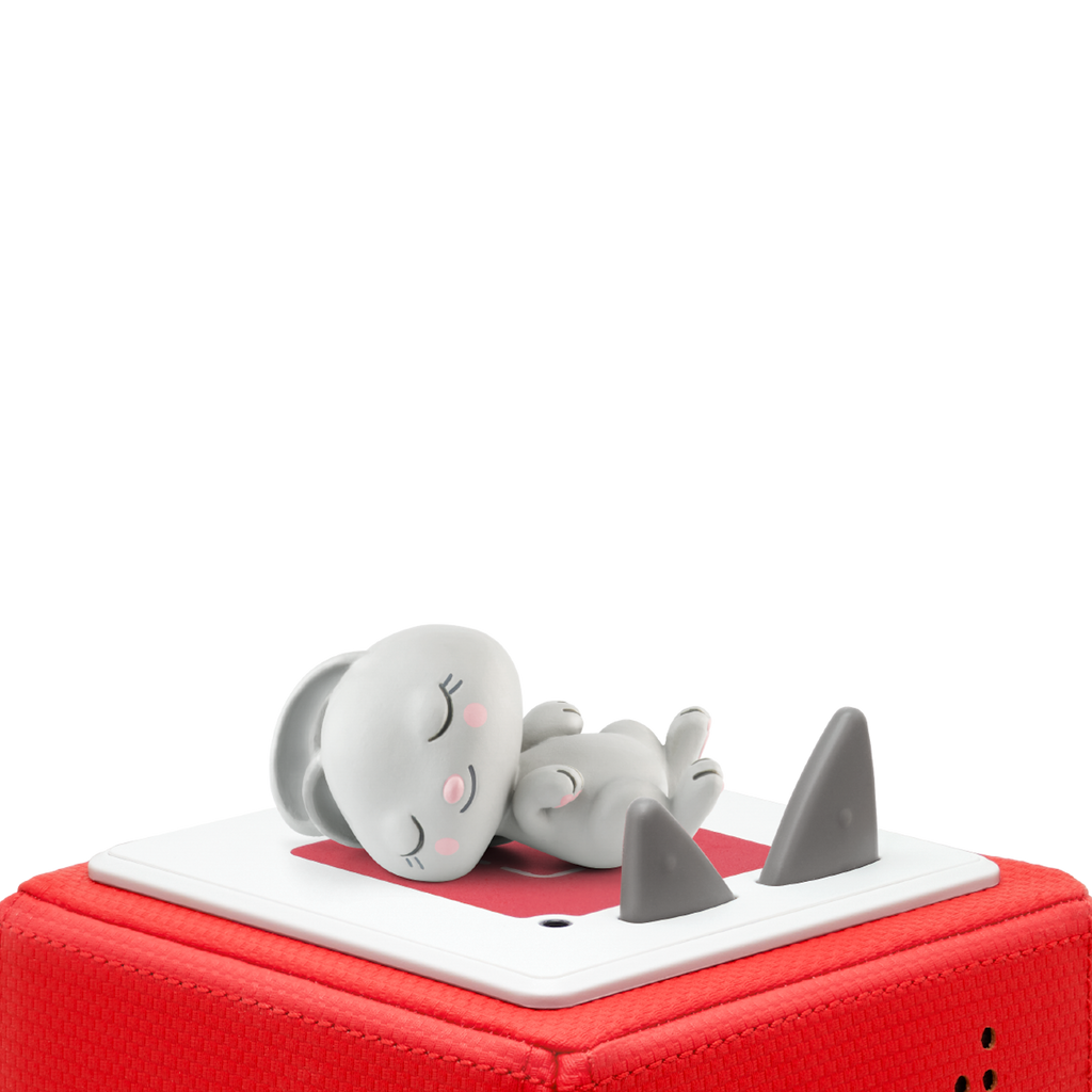 A cute gray figurine of a bunny sleeps peacefully atop a red, soft-textured square base. The background is completely white, highlighting the scene.