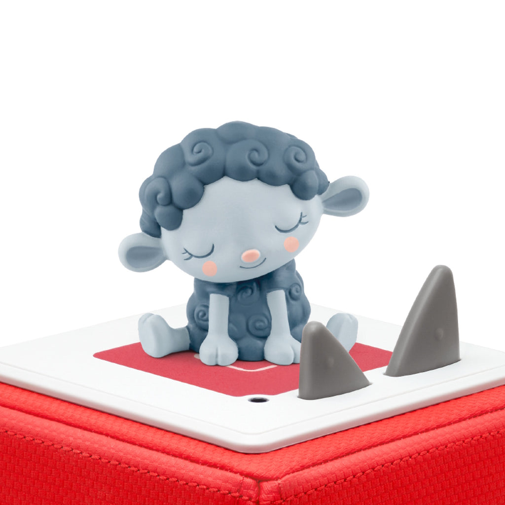 A cute, sleepy blue sheep figurine with closed eyes sits atop a red and white audio box. The scene conveys calmness and serenity.