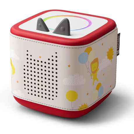 Toniebox speaker featuring a patterned sleeve with floating balloons, a cute lion, clouds, and a sun.