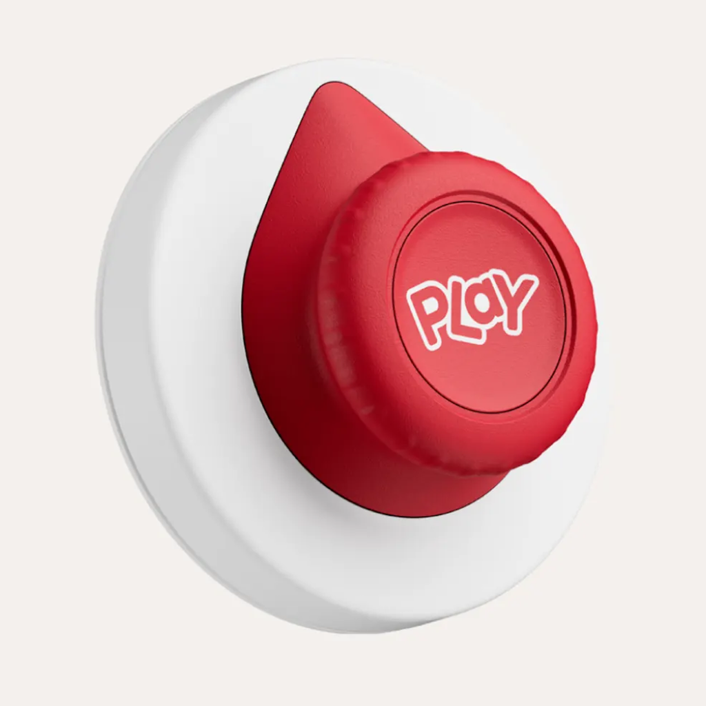 A red, round button with the word "Play" in white sits on a white base. The button has a curved edge, giving it a tactile appearance.