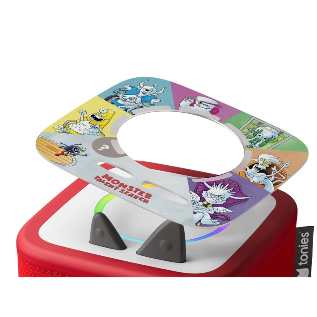 A colorful Tonies figurine atop a red speaker, featuring playful cartoon monsters on a slanted card with "Monster Talent Search" text, creating a whimsical and fun vibe.