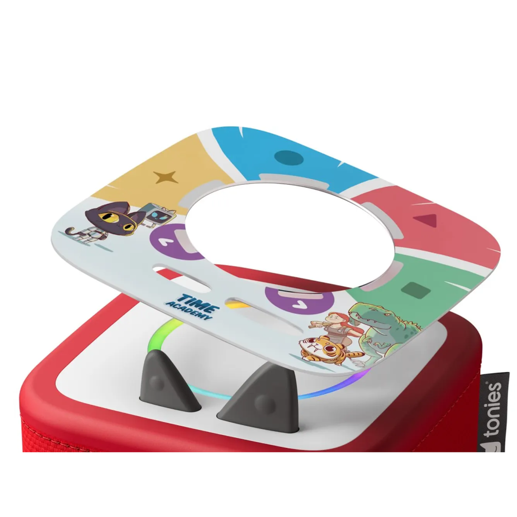 Colorful square plate with cartoon animals and "TIME ACADEMY" text rests on a red speaker. The design is playful, featuring bold shapes and colors.