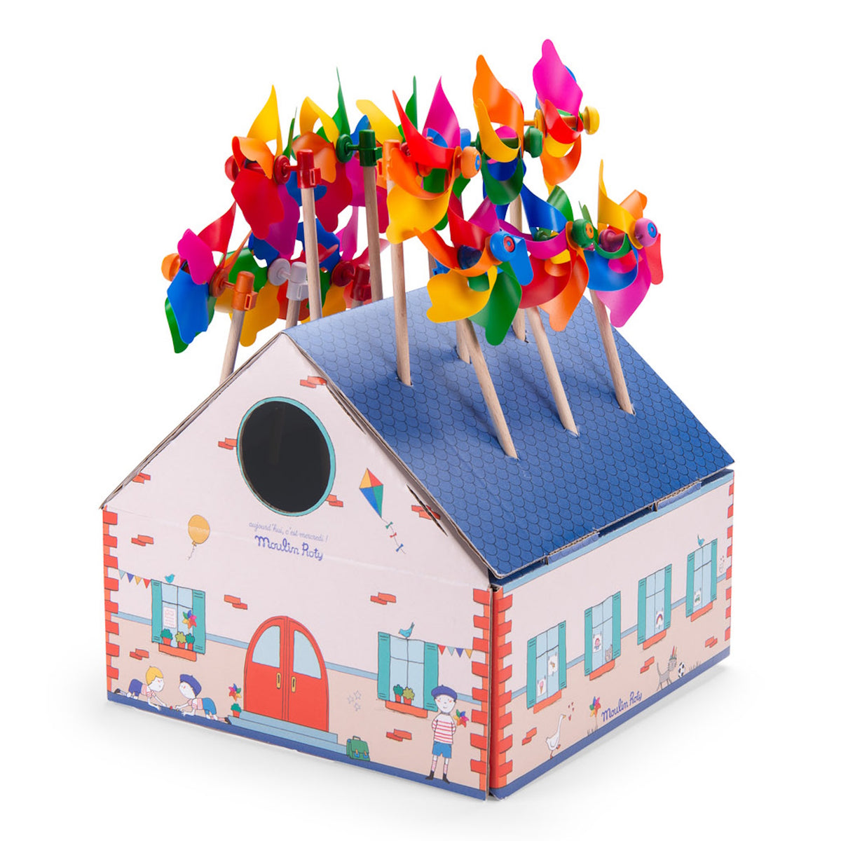 Moulin Roty colorful toy windmills displayed in a cardboard house box, isolated on a white background.