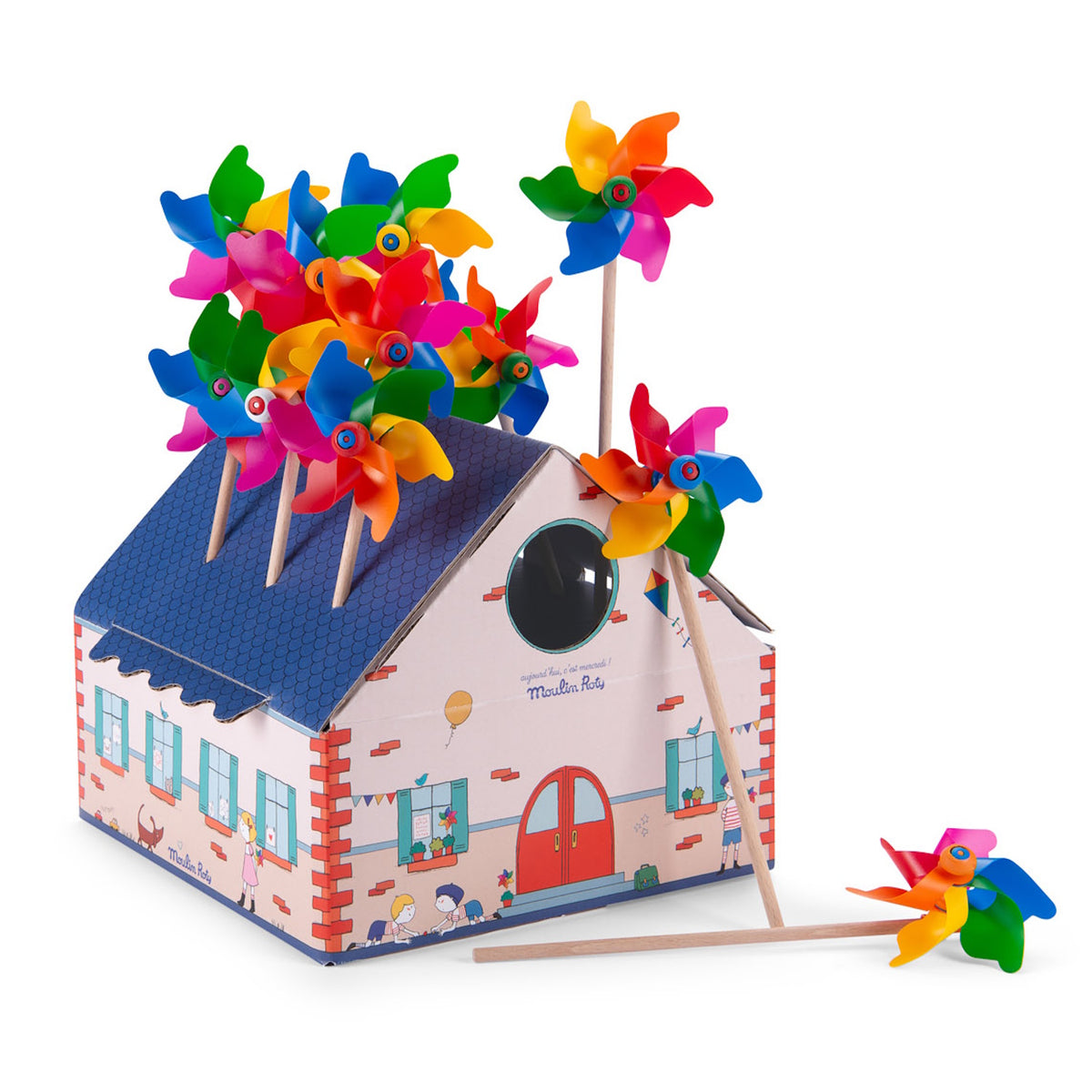 Moulin Roty colorful toy pinwheels displayed in a cardboard house-shaped box with a white background.