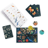 Moulin Roty animal seek and find card game featuring illustrated animal cards, circular tokens, and an animal name guide.