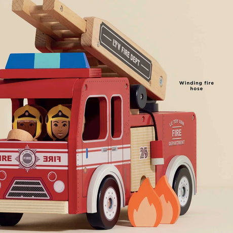 Red wooden toy fire engine with firefighters driving, winding fire hose, and fire cutouts.