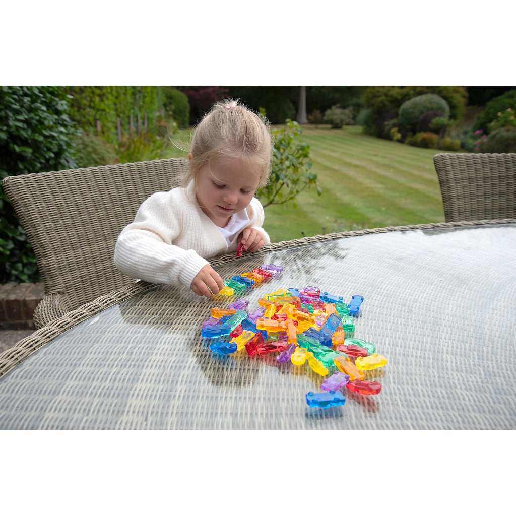 A set of small, see-through plastic cars in bright colors, designed to support imaginative play and color recognition in young children.