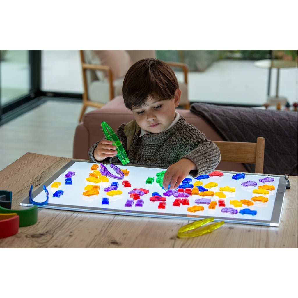 A set of small, see-through plastic cars in bright colors, designed to support imaginative play and color recognition in young children.