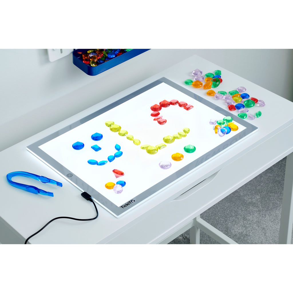A collection of brightly colored, see-through plastic gems, ideal for sensory play, sorting, counting, and light table activities.