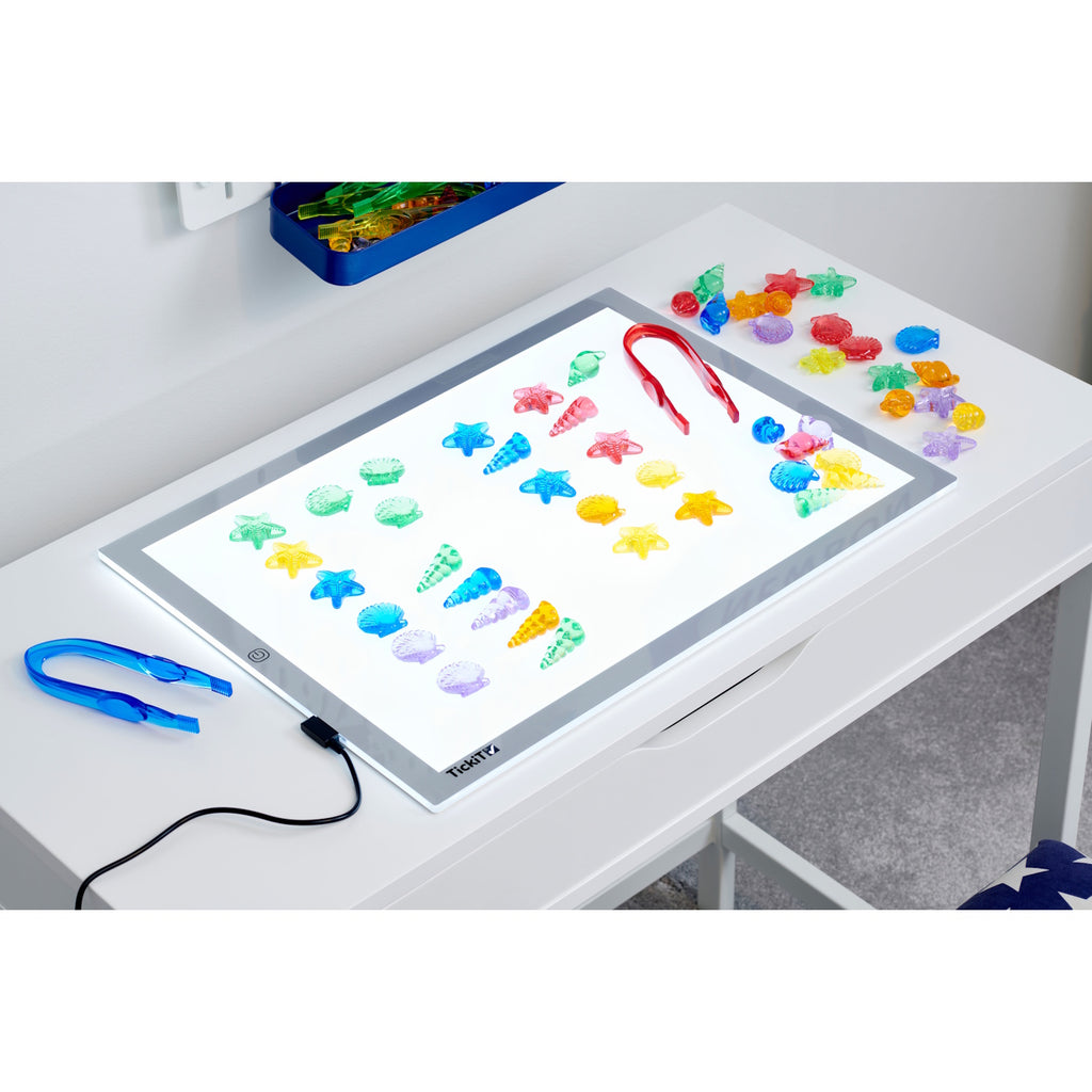 A set of vibrant, see-through plastic shells designed for sensory exploration, sorting, counting, and light-based activities.