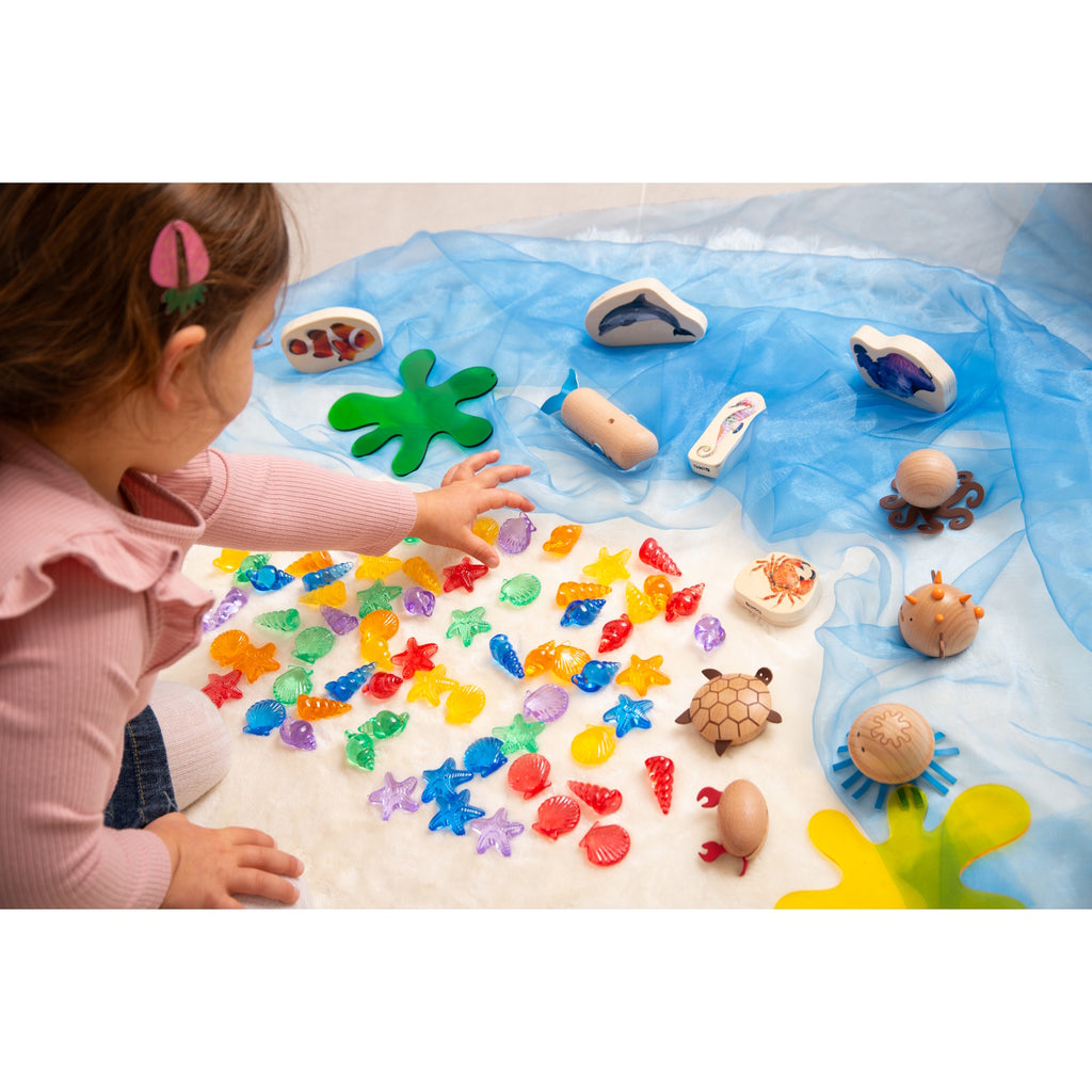 A set of vibrant, see-through plastic shells designed for sensory exploration, sorting, counting, and light-based activities.