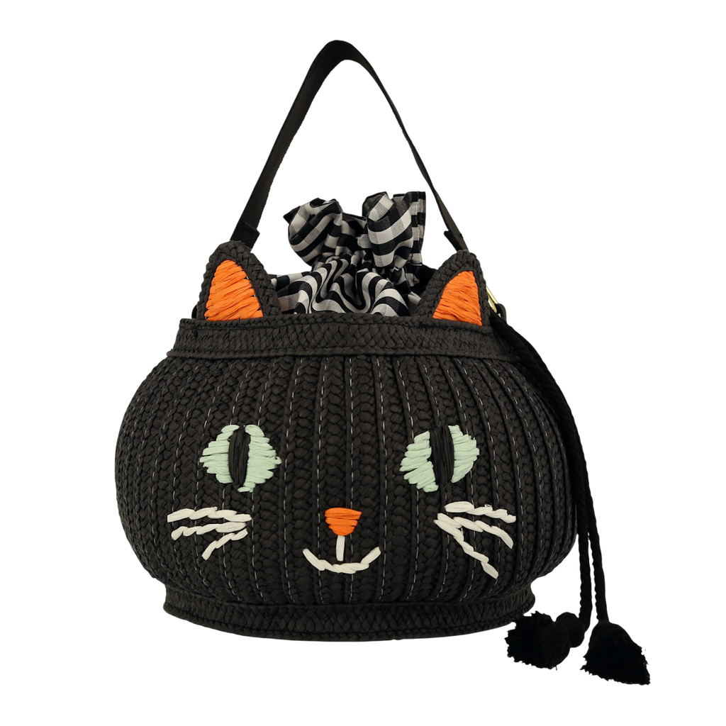 A black woven handbag with a cat face design, orange ears, and green eyes. It features a black and white checkered fabric peeking out from the top.