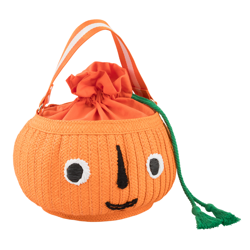 Orange pumpkin-shaped bag with a smiling face, featuring bold black stitched eyes and mouth. It has a drawstring top and green tassel detail. Cheerful tone.