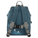 The back view of a blue children's backpack with white specks, gray shoulder straps, and a chest strap.