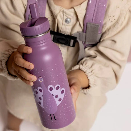 Close-up of a child's hands holding a purple water bottle featuring a cute peacock illustration.