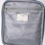 Inside of a lunch bag showing a grey zippered mesh pocket and a Trixie name tag with a cat drawing.