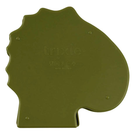 The back of an olive green dinosaur-shaped lunch box with an embossed logo.