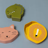 Three animal-shaped lunch boxes: a green dinosaur, a pink cat, and an open yellow lion container.