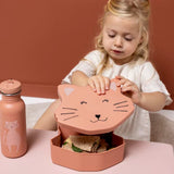 A young girl opens a pink cat-shaped lunch box containing a sandwich, next to a matching cat water bottle.