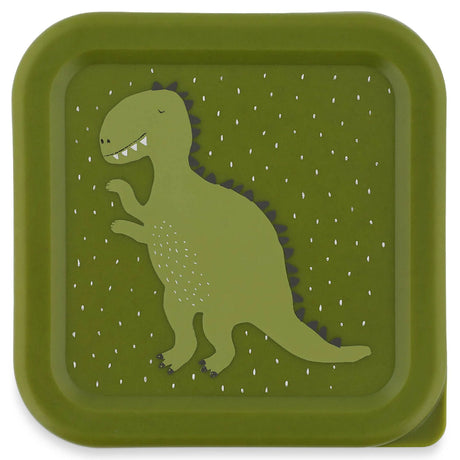 Top view of a square green snack box lid featuring a cartoon dinosaur with a white speckled pattern.