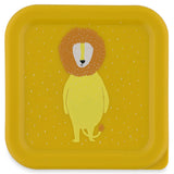 Top-down view of a square yellow snack box lid featuring a cute cartoon lion illustration with white specks.