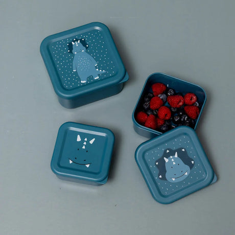 Blue triceratops dinosaur nesting snack boxes, with one open container showing fresh berries inside.