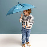 A smiling toddler in a striped sweater holds a blue, patterned dinosaur umbrella with pop-out ears.
