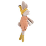 Side profile of a plush rabbit wearing a mustard yellow pointed hat, socks, and a clay romper with a fuzzy tail.