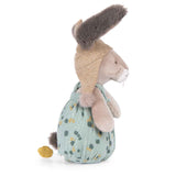 Side profile of a plush rabbit wearing a pointed tan hood and green floral overalls against a white background.