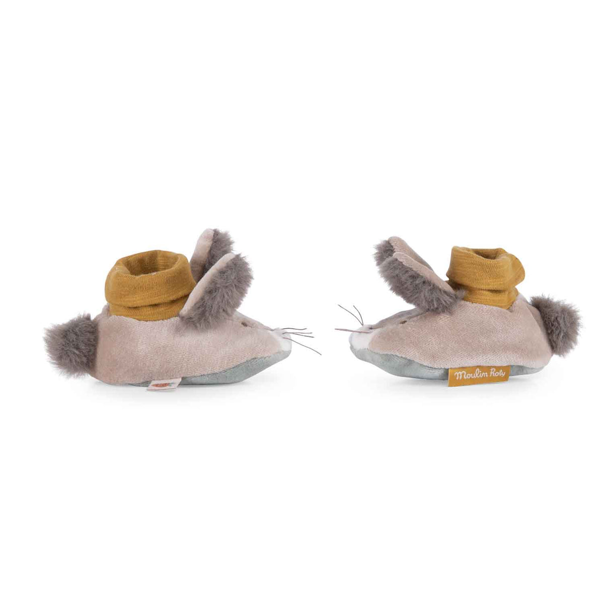 A pair of tan plush baby slippers shaped like rabbits with fuzzy ears, pom-pom tails, and mustard yellow cuffs.