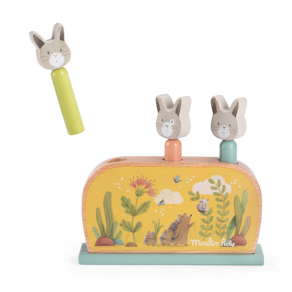 Wooden toy with bunny heads on colored pegs, one detached. Base features yellow graphics of flowers, a mouse, and a hedgehog in a whimsical style.