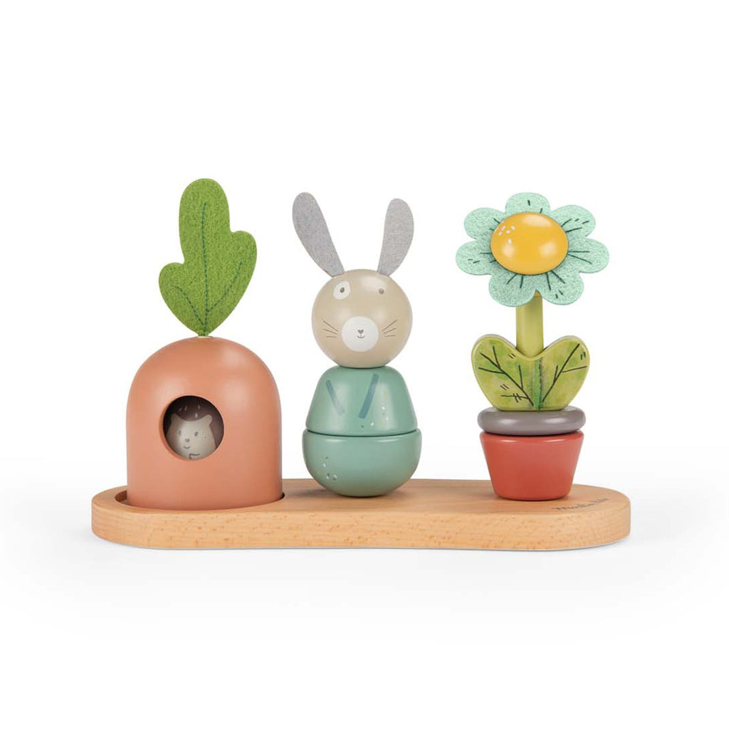Whimsical wooden toy set featuring a rabbit, carrot, and flower on a wooden base. Each is colorful and expressive, evoking playful joy.