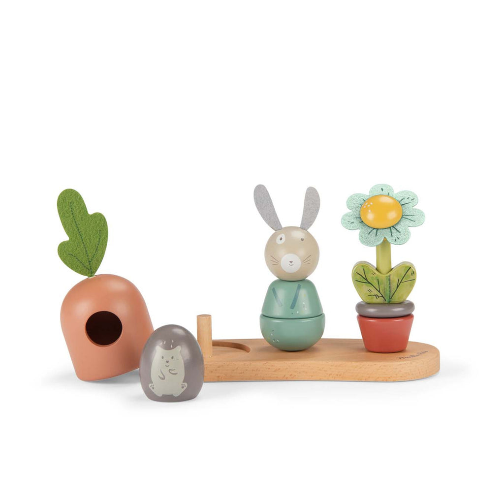 Whimsical wooden toy set featuring a rabbit, carrot, and flower on a wooden base. Each is colorful and expressive, evoking playful joy.