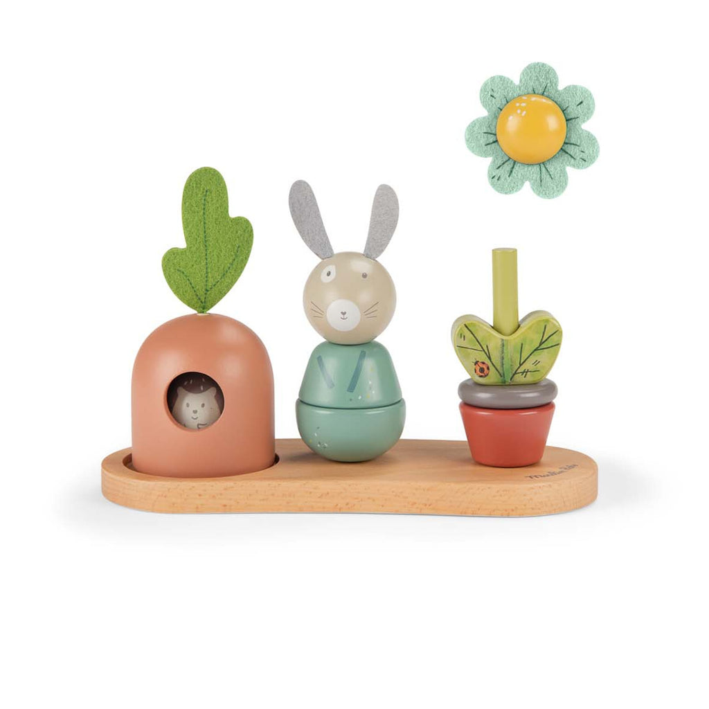 Whimsical wooden toy set featuring a rabbit, carrot, and flower on a wooden base. Each is colorful and expressive, evoking playful joy.