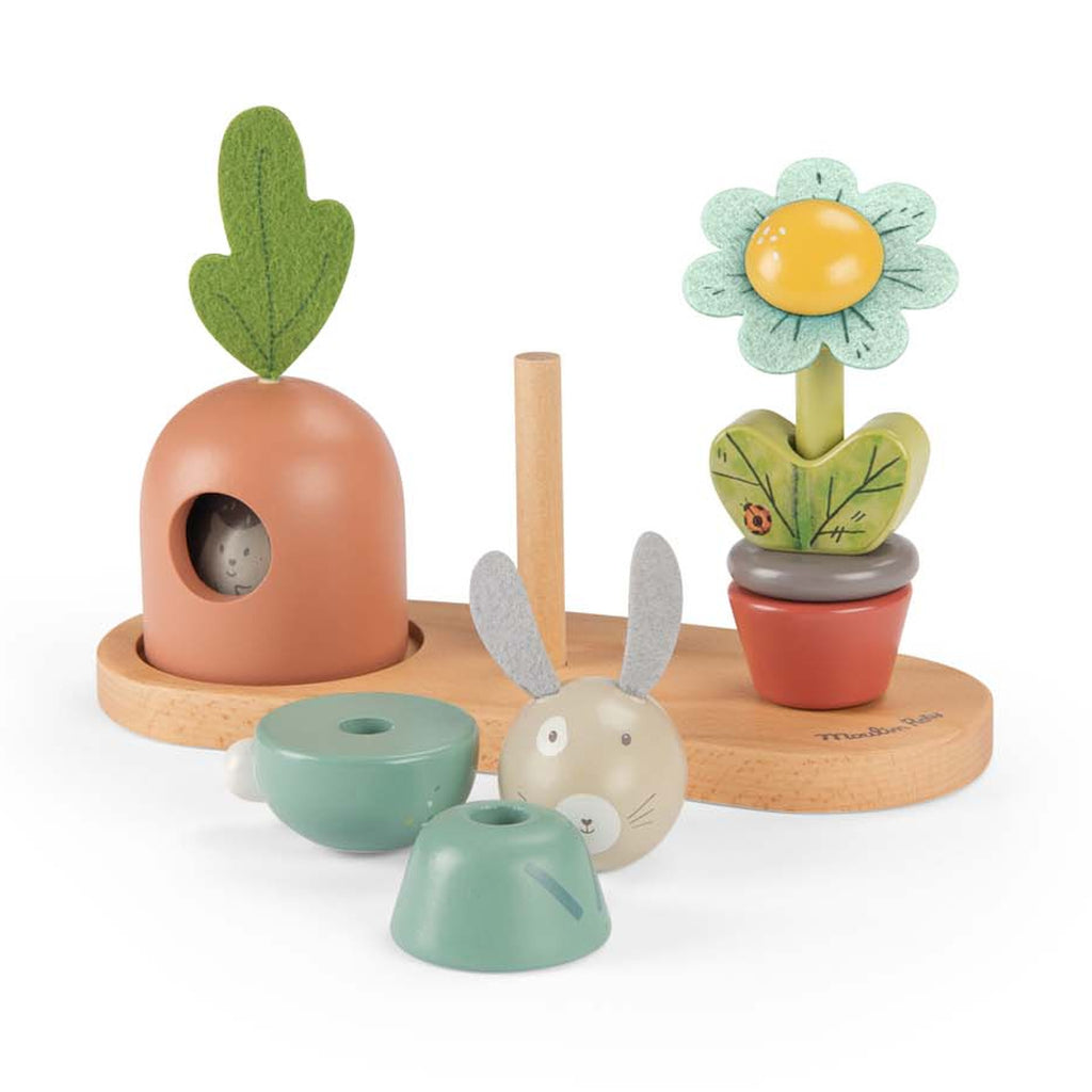 Whimsical wooden toy set featuring a rabbit, carrot, and flower on a wooden base. Each is colorful and expressive, evoking playful joy.