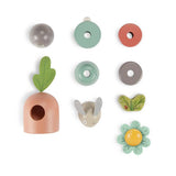 Moulin Roty Trois Petits Lapins wooden stacking toy disassembled pieces including bunny carrot and flower.