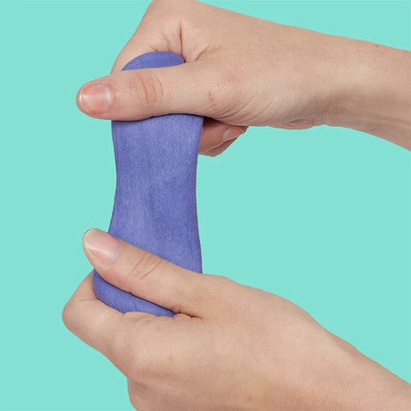 Two hands pulling and stretching periwinkle focus putty vertically against a bright teal background.