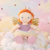 Olli Ella Dinkum Doll wearing a unicorn outfit set, sitting on clouds with a dreamy sky backdrop.