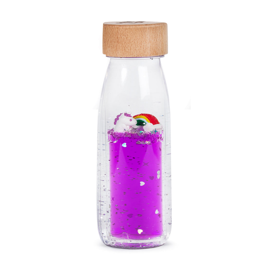  A sensory bottle filled with purple liquid, featuring two small unicorn figures and a rainbow floating inside.