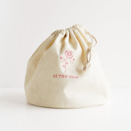Cream drawstring storage bag for a wooden beauty toy set, featuring a rose print logo.