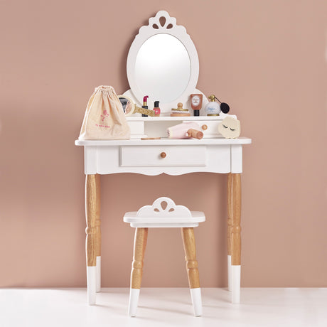 White wooden toy vanity table and stool set up with play beauty accessories and a storage bag.