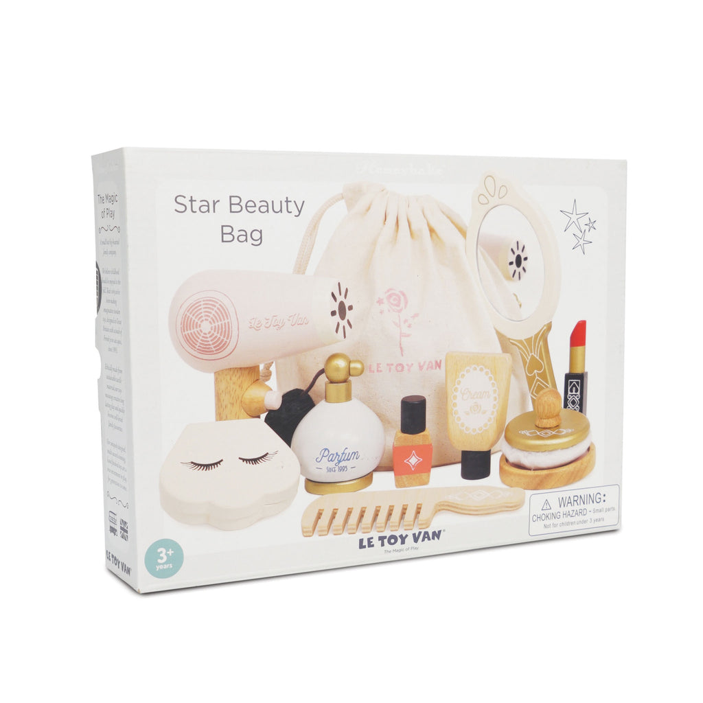 Toy beauty set labeled "Star Beauty Bag" displayed in packaging. Includes toy hairdryer, mirror, comb, lipstick, and perfume, in soft pastel colors.