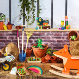 Colorful Vilac wooden garden toys, including a fox rocker, shovels, and play vegetable sets, arranged in a garden scene.